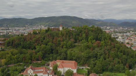 Vista-Aérea-Hacia-El-Interior-De-La-Ciudad-De-Graz-Dolomita-Schloßberg-Hilltop-Forest-En-Graz-Austria