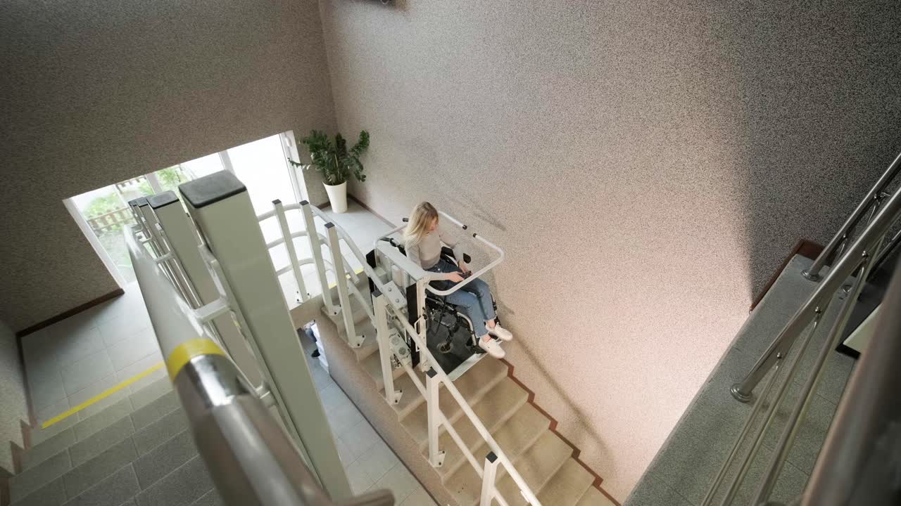 체어를 타고 있는 소녀가 계단 엘리베이터를 이용해 어렵지 않게 계단을 올라갑니다.