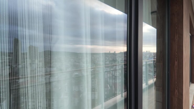 Window view of a city skyline with layered curtains