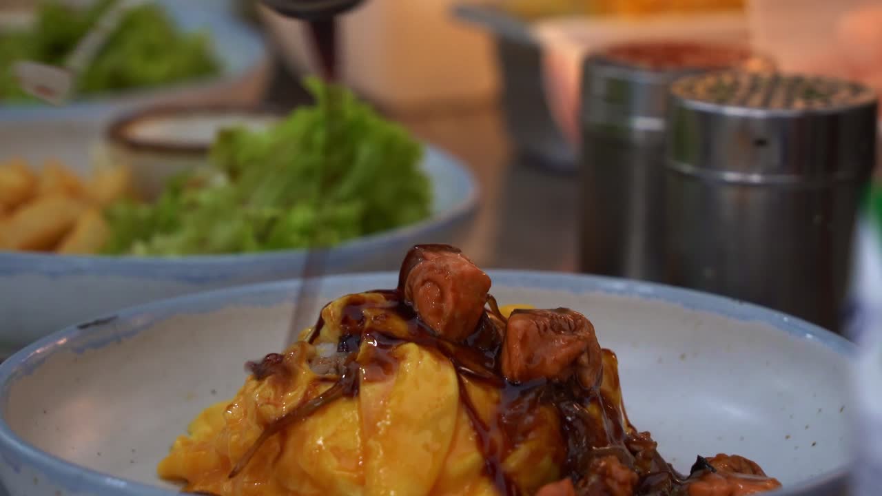 rocíe deliciosa salsa teriyaki sobre arroz omu de salmón japonés plateado, aleje la toma