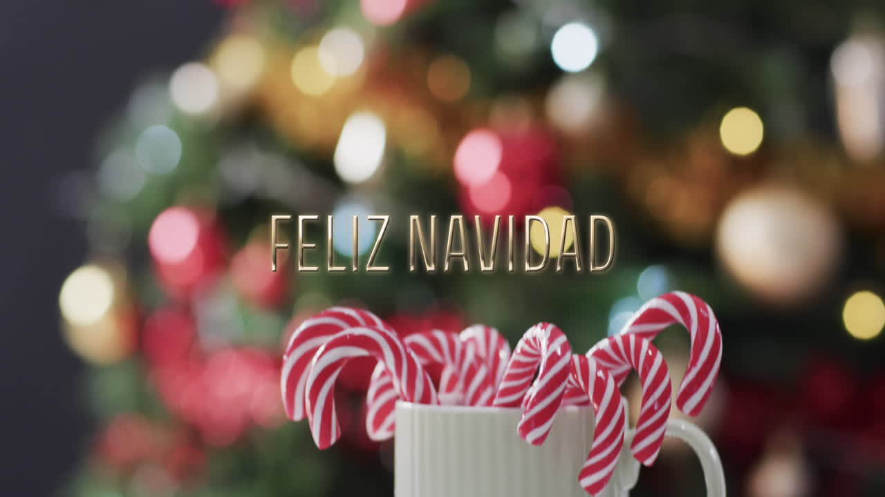 texto de feliz navidad y latas de caramelo sobre luces desenfocadas en el árbol de navidad