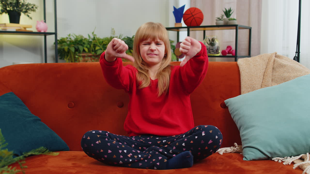 расстроенная подростка показывает большой палец вниз, не нравится плохая работа, неодобрение, неудовлетворенная обратная связь дома