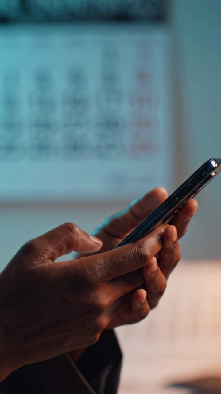 Close-up of Hands Using a Smartphone with a Calendar in the Background, Showcasing Daily Tasks and Digital Engagement in a Modern Lifestyle Setting