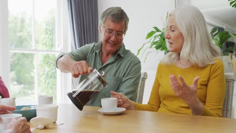 Animation-Glücklicher-Kaukasischer-Weiblicher-Und-Männlicher-älterer-Freunde,-Die-Zu-Hause-Kaffee-Trinken