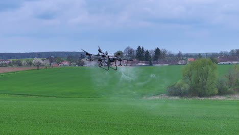 Aviones-No-Tripulados-Agrícolas-Volando-Y-Rociando-Fertilizantes-En-Campos-Agrícolas-Verdes,-Rastreando-Vistas-Aéreas