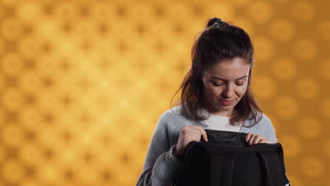 Portrait-of-woman-rummaging-through-backpack,-taking-book-out