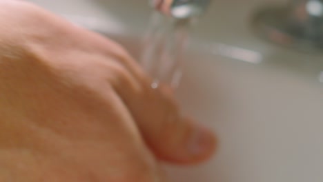 Water Flowing Over Hands in White Sink as They Rub Together with Soap to Remove Germs and Viruses. Slow Motion Healthy Hygiene Practice