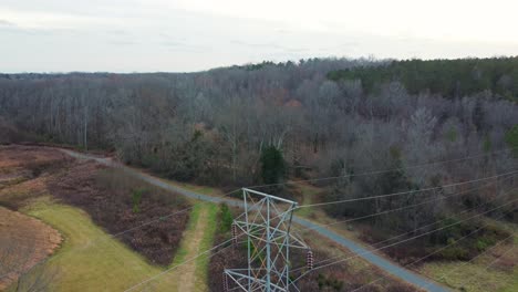 drone revelando un primer plano de una torre de línea de energía de alto voltaje que transporta energía en abersham park cerca de davidson, carolina del norte