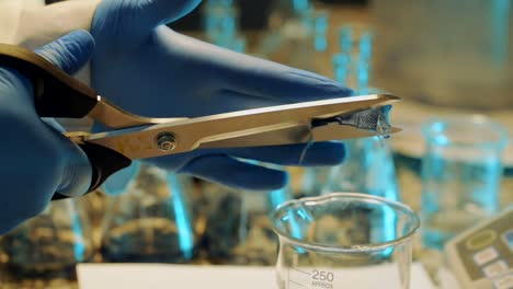 in the lab, the researcher cuts the denim fabric into the test tube