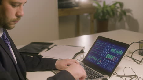 Caucasian-bearded-man-working-in-office-while-typing-on-laptop