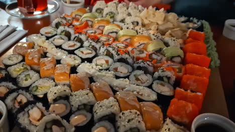 plate with many various sushi on dinner date, handheld zoom in shot