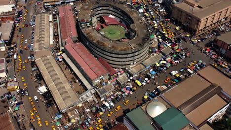 Aerial-view-tilting-over-market-stalls-and-tents,-overlooking-the-cityscape-of-Yaounde,-Cameroon