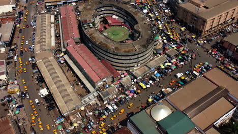 aerial view tilting over market stalls and tents, overlooking the cityscape of yaounde, cameroon