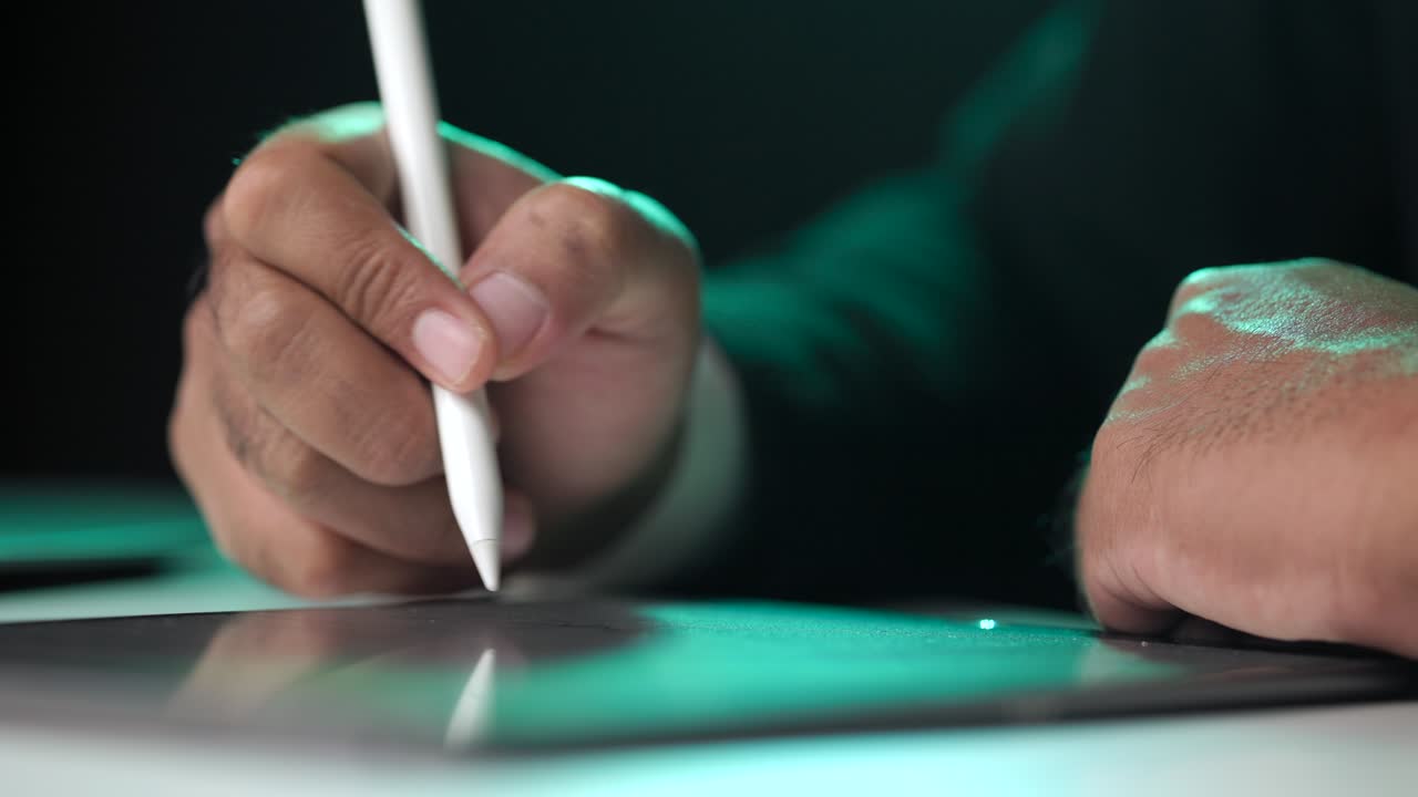 Electronic signature with green light. Businessman signing a business contract with stylus pen on tablet at night. Man signing contract on tablet at office. Business and technology concept.