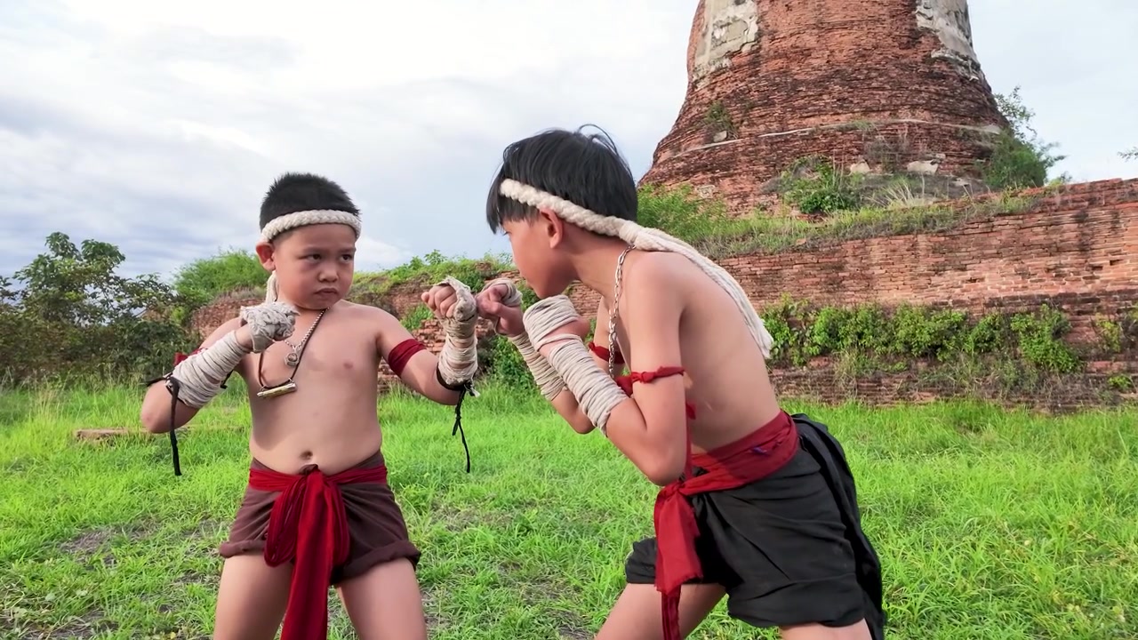 Nuoret pojat esittävät perinteistä Muay Thai -nyrkkeilyä historiallisilla Ayutthayan raunioilla Thaimaassa