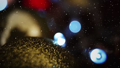 video composition with falling snow over blurry video with lights and golden bubble