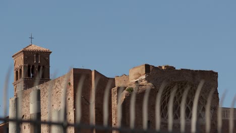 still far shot for ancient old church building in the roman forum area with blurred foreground fences