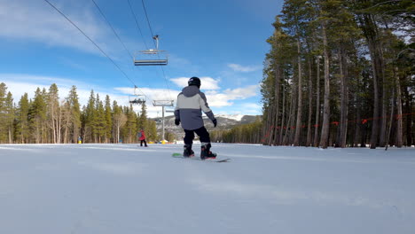 adolescente en una tabla de snowboard realiza un deslizamiento de talón
