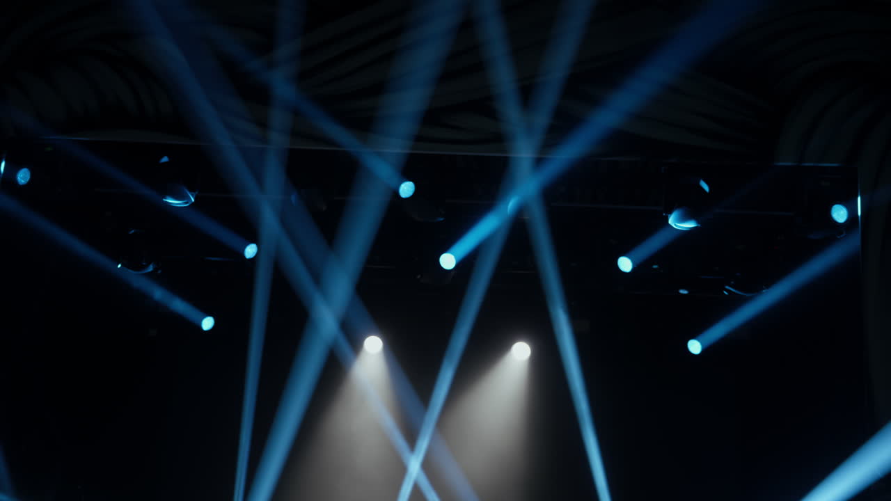 Dynamic Blue and White Stage Lights Illuminating a Dark Venue