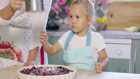 adorable little girl engrossed in baking a pie