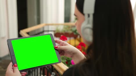 maquillaje de manos de mujer sosteniendo una tableta pc con pantalla blanca en blanco auriculares para el oído