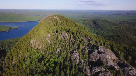 Aerial footage flying along the ridge of a partially exposed (rock) mountain ridge all the way to the summit.