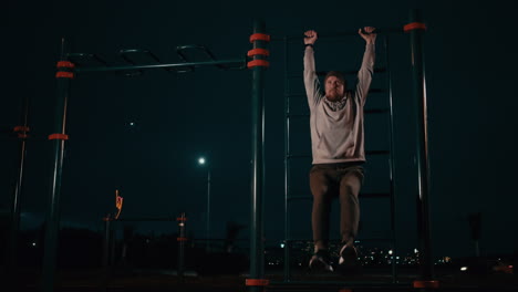 man doing pull-ups at night