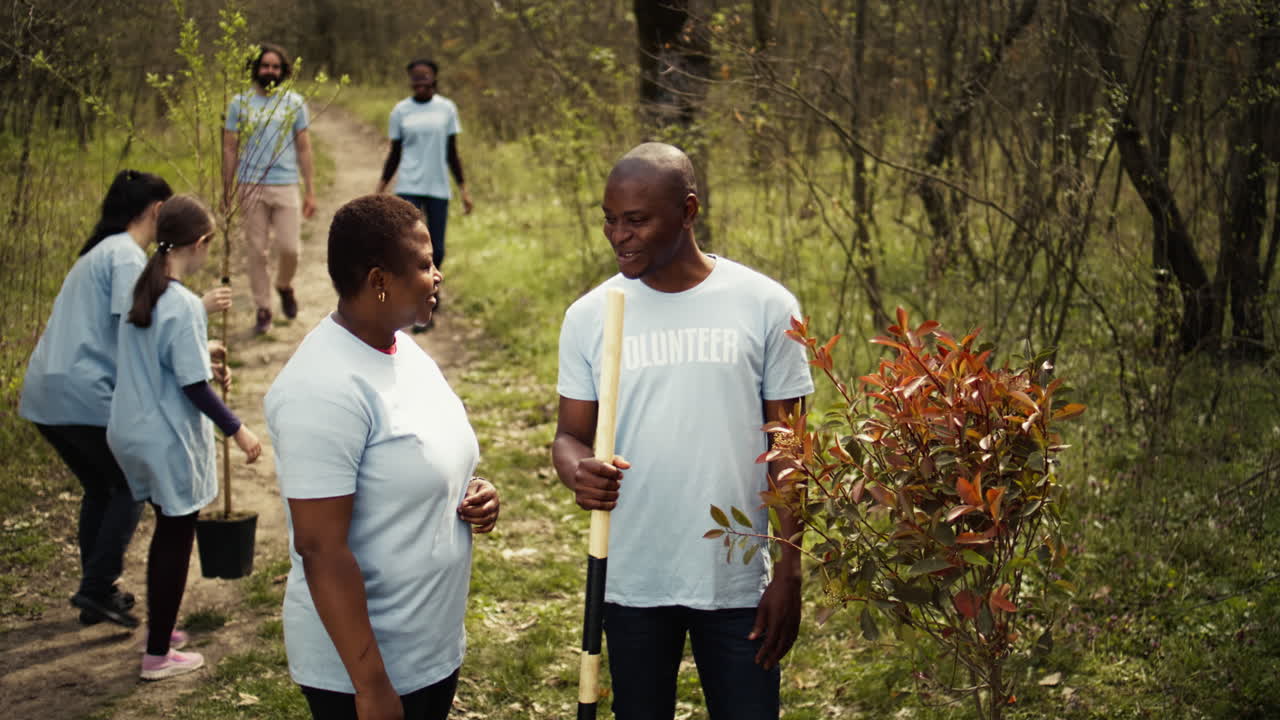 Portrait of couple volunteering to plant trees and collect trash from the woods