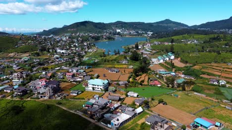 volando sobre casas coloniales en nuwara eliya hacia el impresionante lago gregory, agua clara bajo un cielo azul, sri lanka