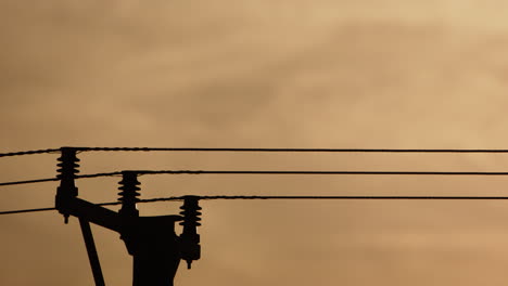 Silueta-De-Líneas-De-Suministro-De-Energía-Eléctrica-De-Alto-Voltaje-Contra-El-Cielo-Vívido-De-La-Puesta-De-Sol