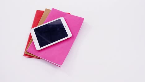digital tablet on stack of books