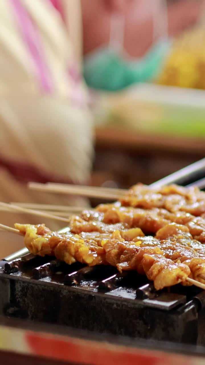 Street vendor grilling skewers at floating market