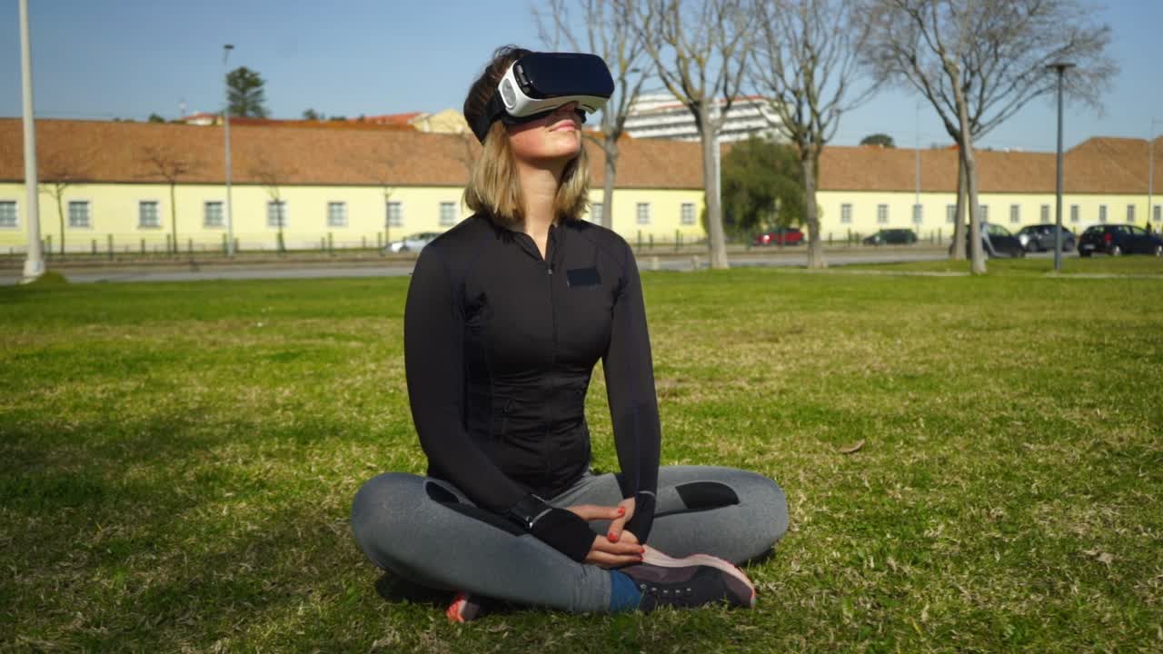 счастливая девушка в спортивной одежде, использующая vr-гарнитуру в парке