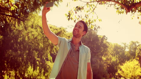 hombre guapo tomando una selfie en el parque