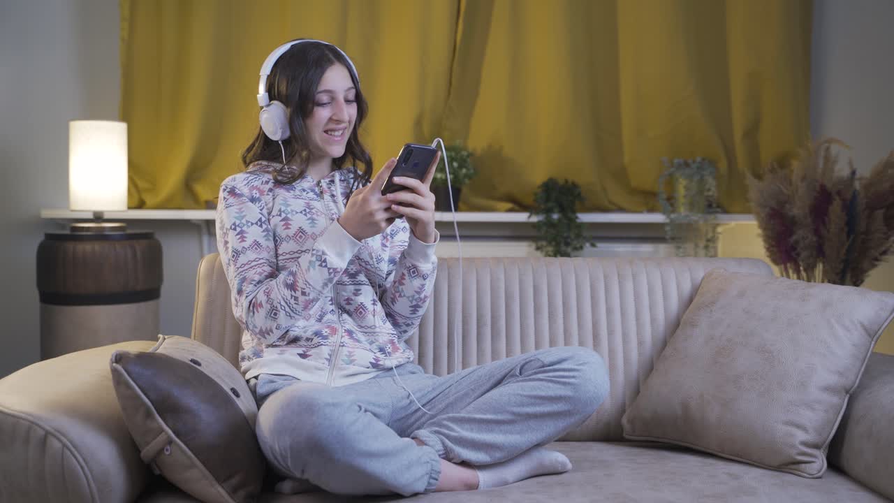 행복한 표정으로 전화로 문자 메시지를 보내는 젊은 여성.