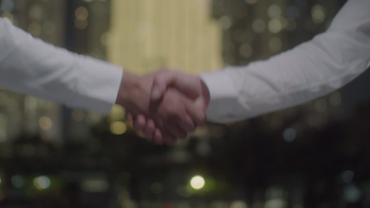 Handshake of Two Businessmen Outdoor at Night