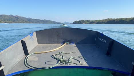 tilt up establishing on a small wooden boat cruising the waters of the gulf of thailand on a sunny, clear day