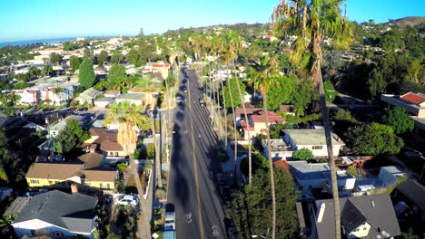 Hermosa-Toma-Aérea-Sobre-Una-Calle-Bordeada-De-Palmeras-En-El-Sur-De-California