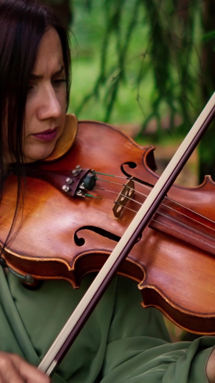Woman Playing Violin in a Forest Setting