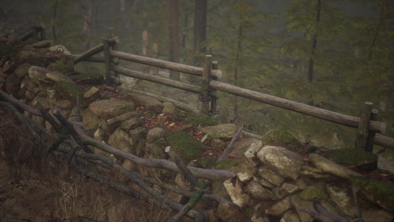 una vieja valla de madera con un campo de campo detrás de ella