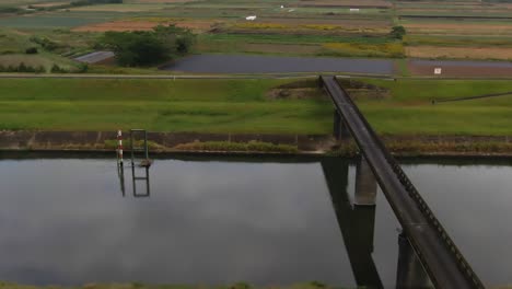 Vista-Aérea-De-La-Campiña-Japonesa-Con-Puente-Y-Río.