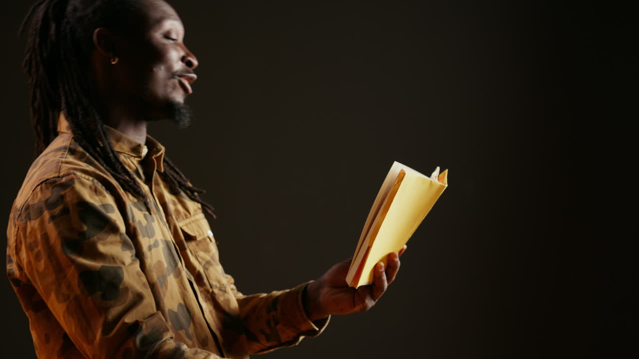 Young adult reading literature book on camera