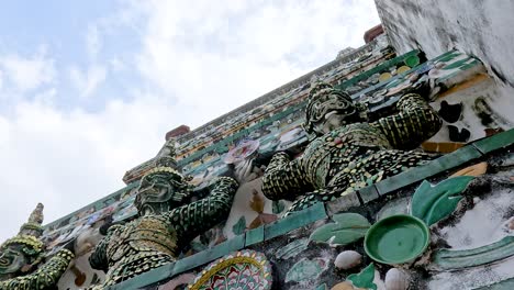 detailed view of ornate statues at wat arun temple, bangkok