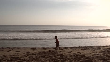 small boy running in slow motion on a beach