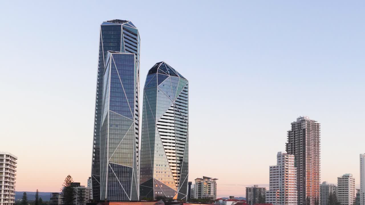 A serene view of Gold Coast skyscrapers at sunset, showcasing modern architecture against a clear sky