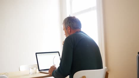 Man-using-laptop-in-living-room-4k