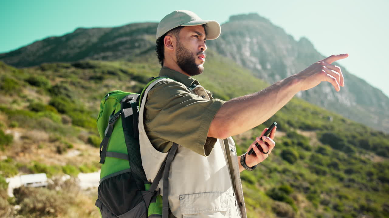 Young Man Using Smartphone for Navigation While Hiking in Mountains