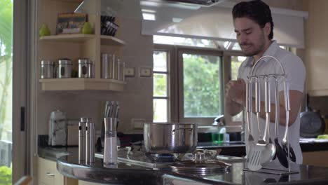 young handsome man tasting food from the pot