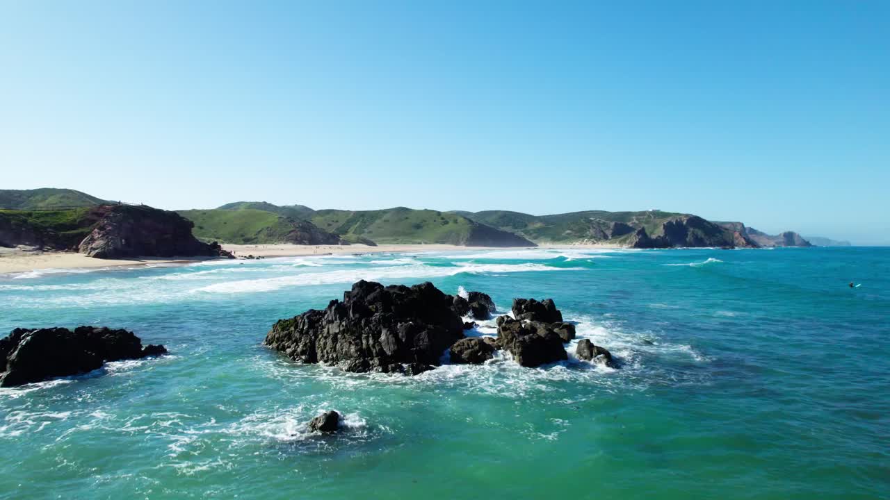 Volando sopra il mare blu con rocce e onde che si infrangono. – Ripresa aerea
