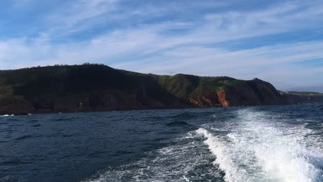 the view from a small vessel cruising past the southern cape coast near the knysna heads on the indian ocean